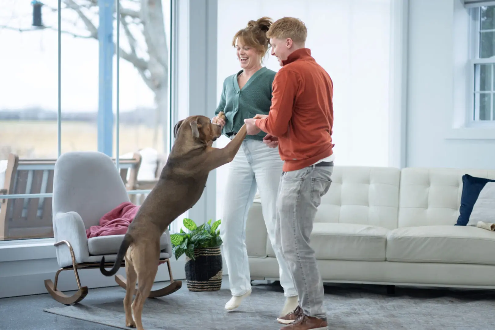 Happy couple and dog in living room