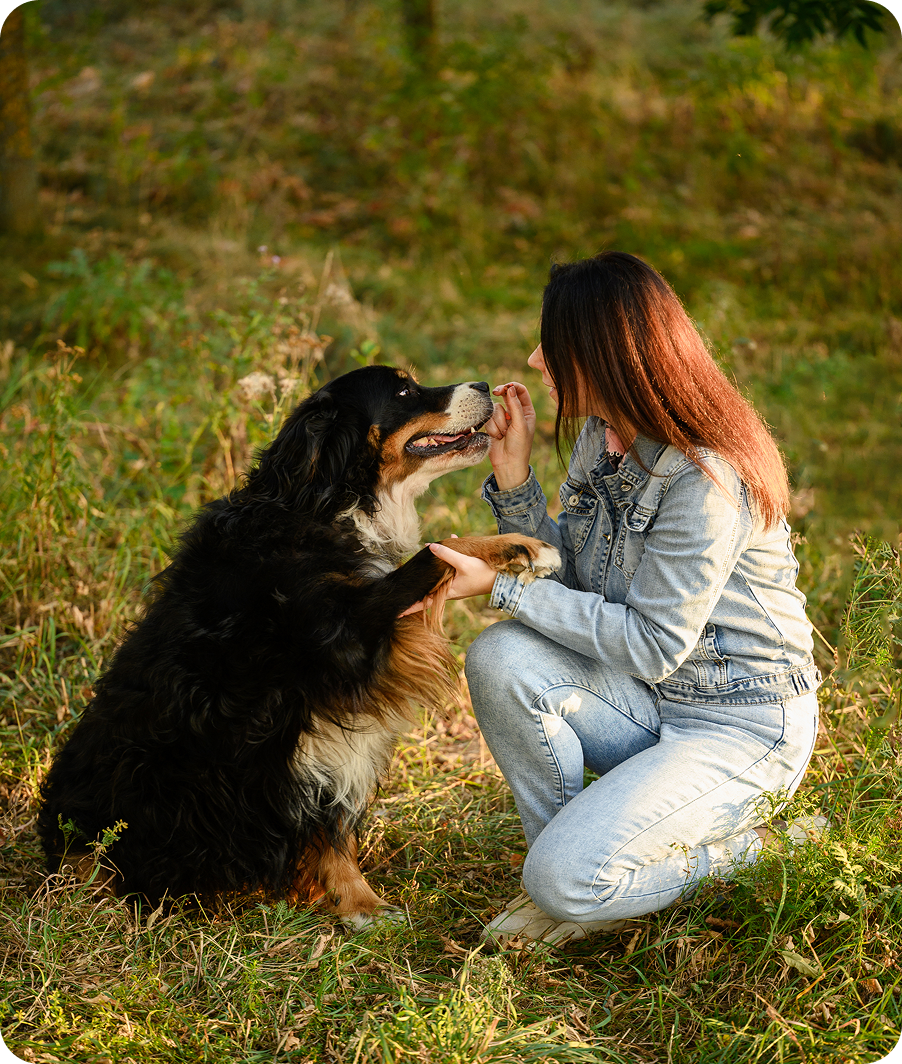 Person kneeling with pet dog