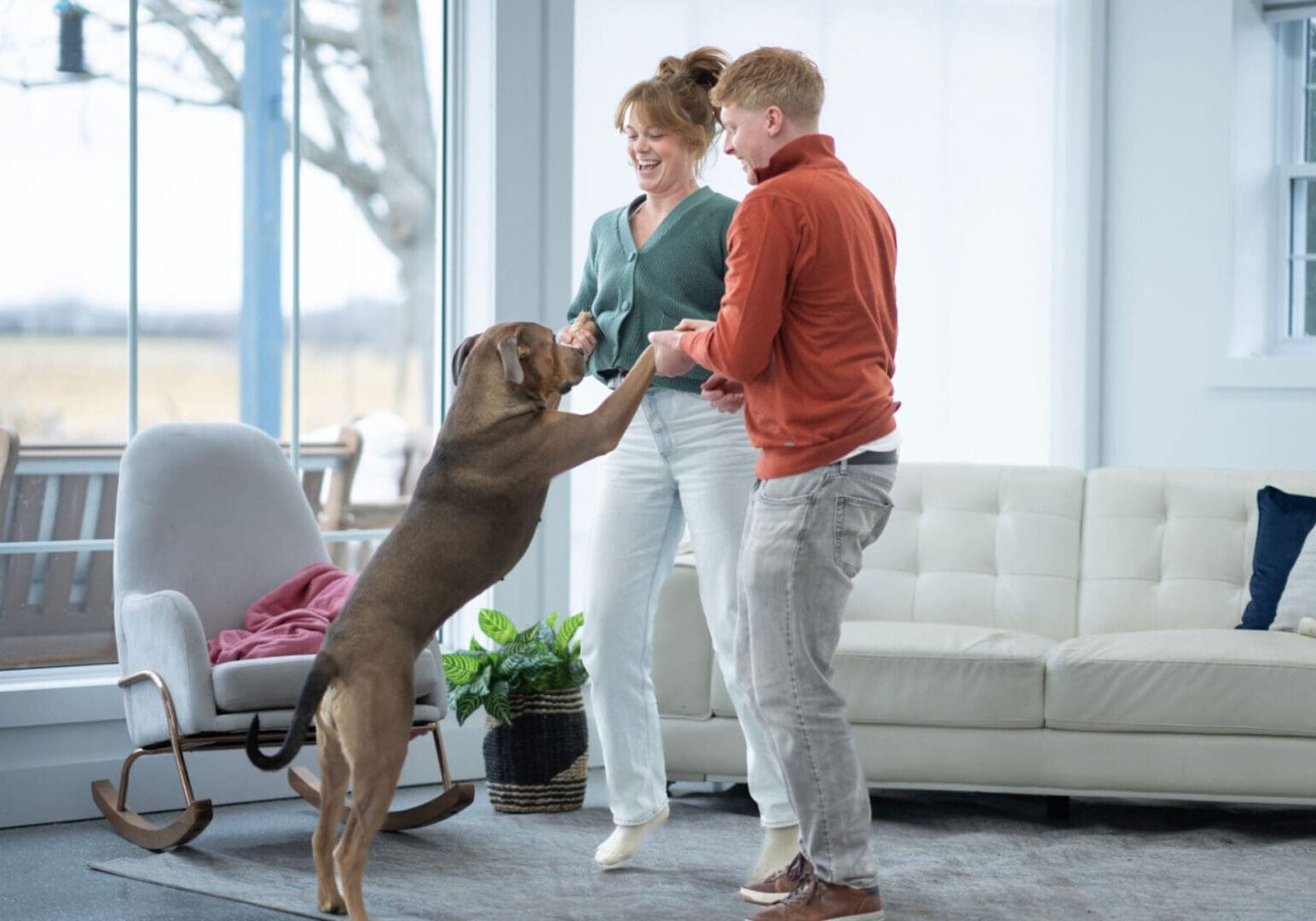 Happy couple and dog in living room